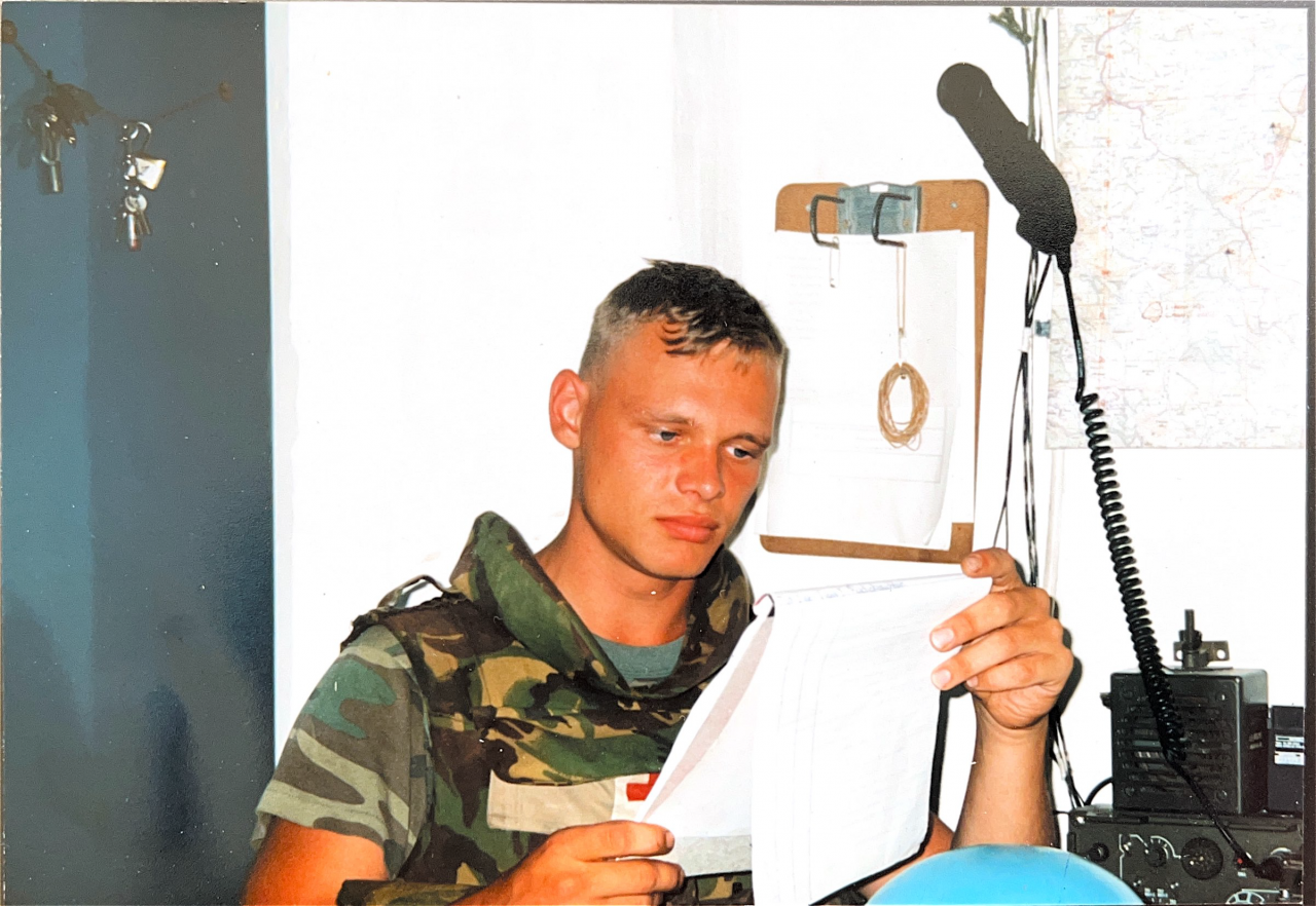 Johan leest een papier in een witte tent in Srebrenica